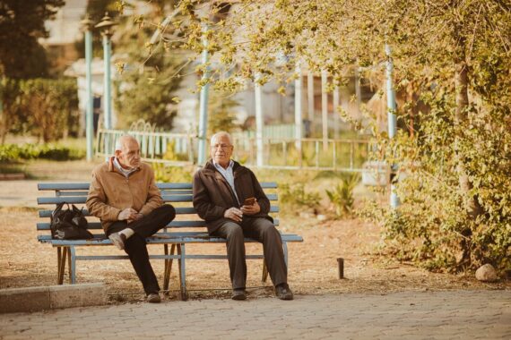 dos adultos mayores sentados en una banca