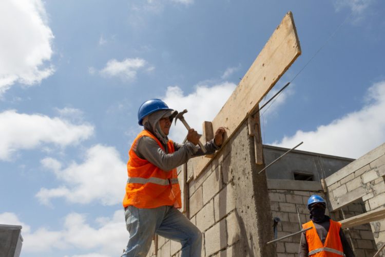 Persona trabajando en construcción, haciendo pared